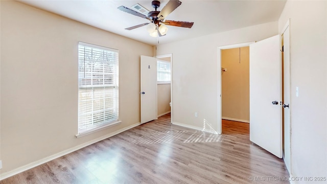 unfurnished bedroom with light wood finished floors, a ceiling fan, visible vents, and baseboards