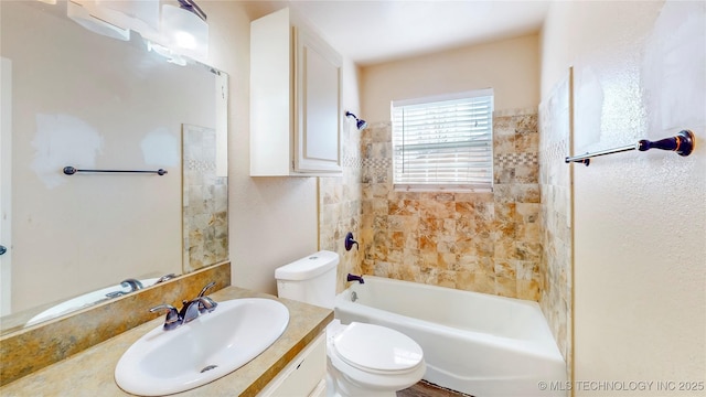 bathroom featuring toilet, vanity, and bathing tub / shower combination