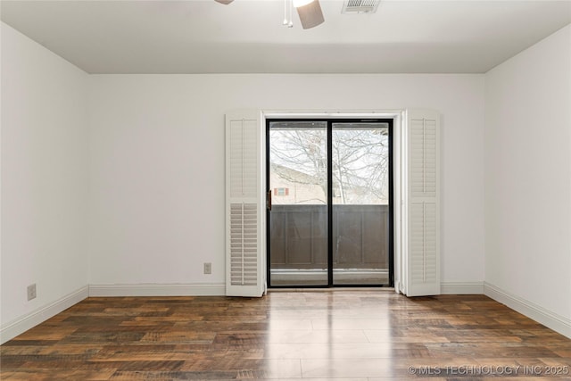 empty room with ceiling fan, dark wood-type flooring, and baseboards