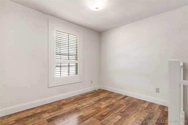 spare room featuring wood finished floors and baseboards