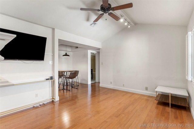 interior space with baseboards, visible vents, lofted ceiling with beams, and light wood finished floors