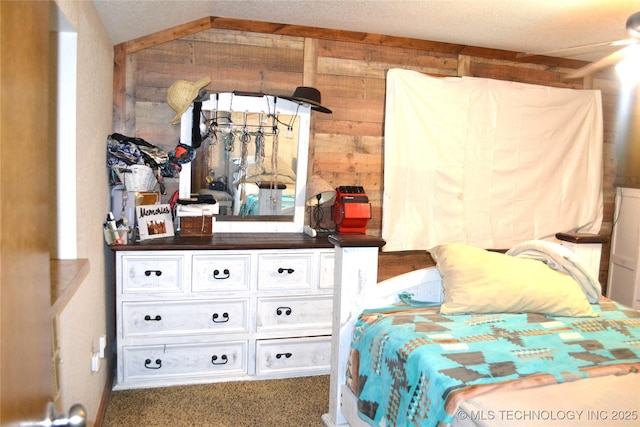 carpeted bedroom with vaulted ceiling and wooden walls