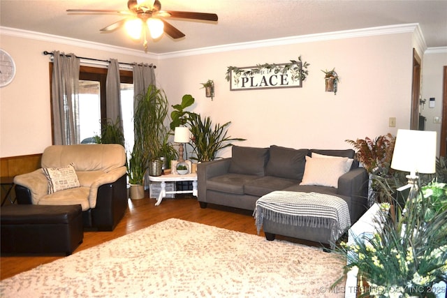 living area with a ceiling fan, crown molding, and wood finished floors