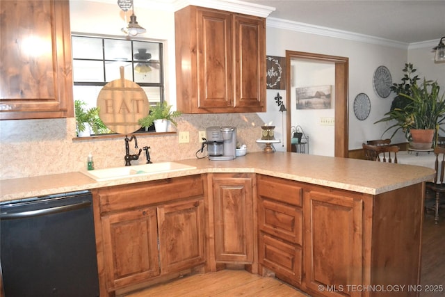 kitchen featuring a sink, black dishwasher, light countertops, ornamental molding, and brown cabinetry