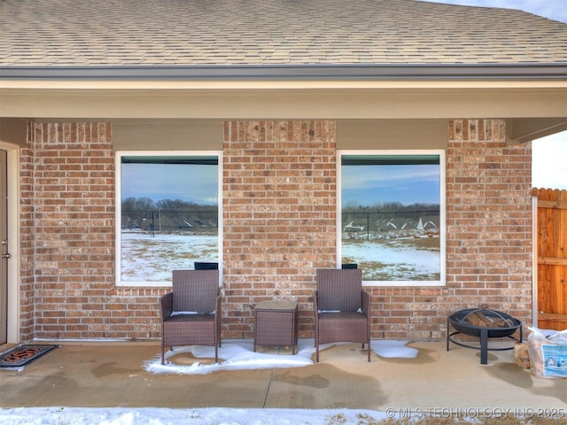 snow covered patio featuring a fire pit