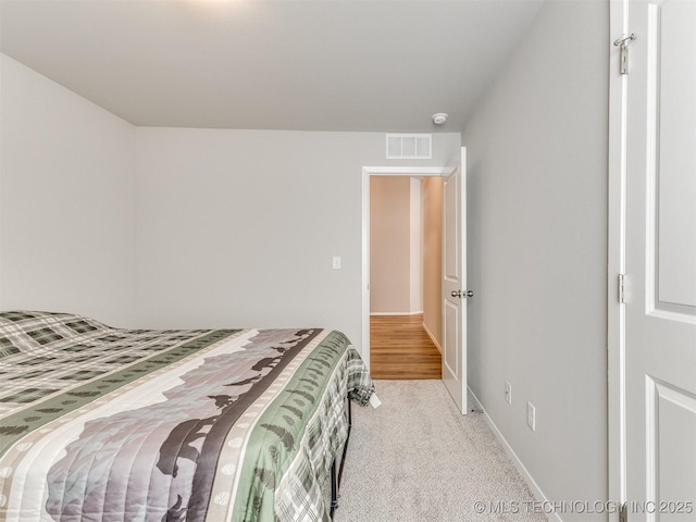 bedroom with light colored carpet, visible vents, and baseboards