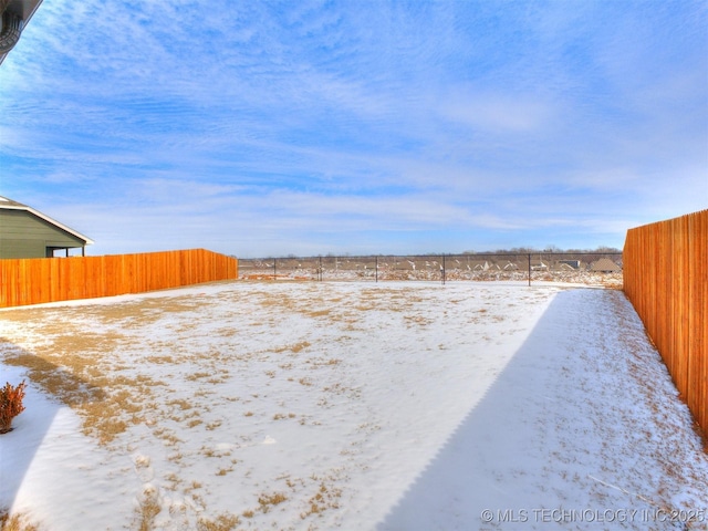 snowy yard featuring fence