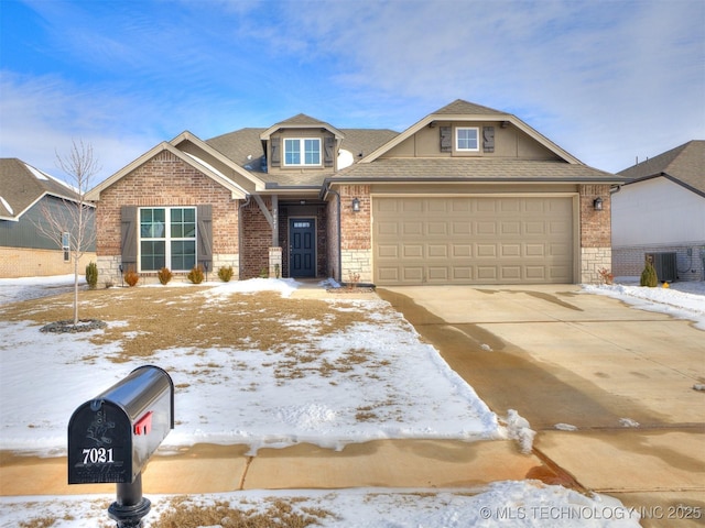 craftsman-style home with a garage, brick siding, driveway, and a shingled roof