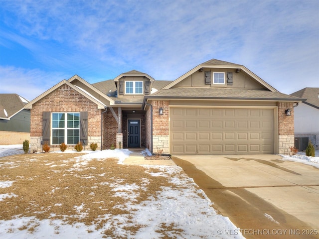 craftsman inspired home with a garage, driveway, brick siding, and central AC