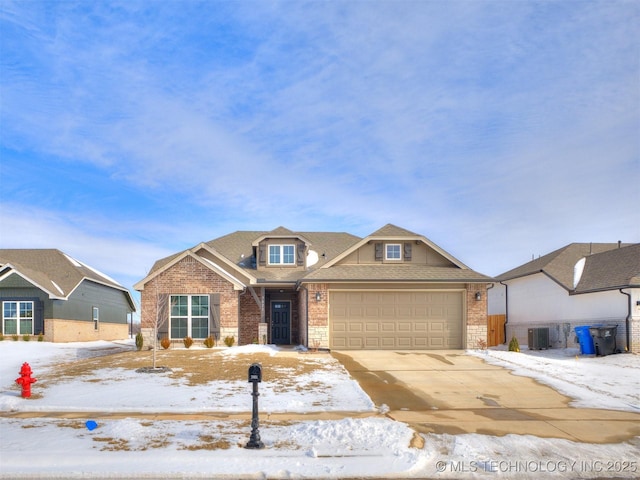 view of front of home featuring concrete driveway, brick siding, an attached garage, and central air condition unit