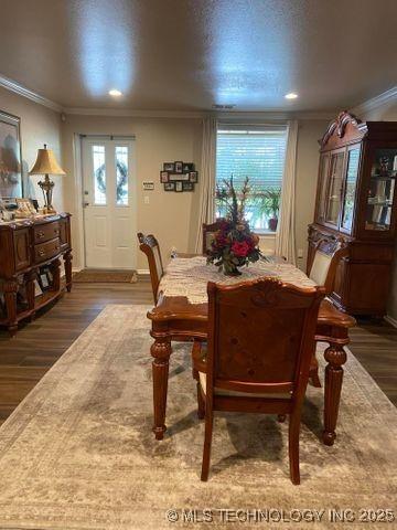 dining room with a wealth of natural light, dark wood-style flooring, and crown molding