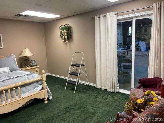 bedroom with dark colored carpet, visible vents, a paneled ceiling, and baseboards