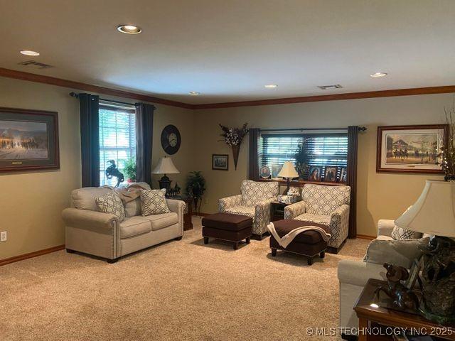 living room with light carpet, ornamental molding, visible vents, and baseboards