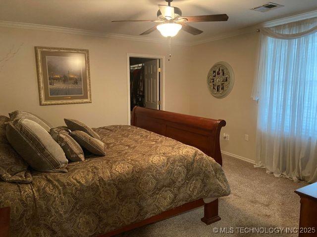 bedroom featuring a ceiling fan, carpet, visible vents, and crown molding
