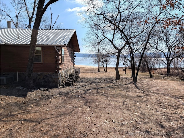 view of yard featuring a water view and central AC unit