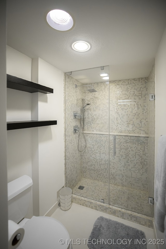 bathroom with a stall shower, a textured ceiling, and toilet