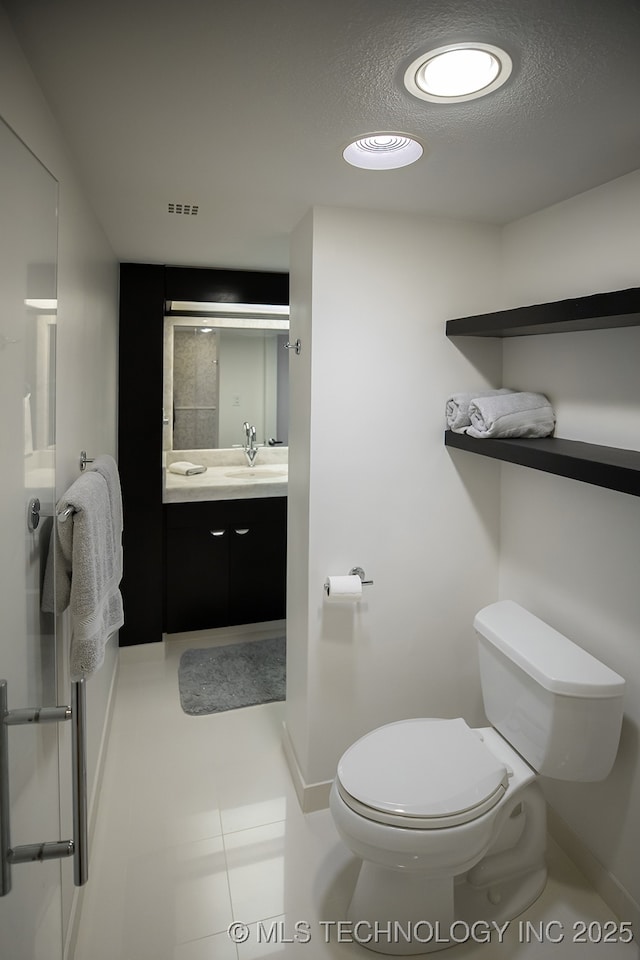 bathroom with baseboards, visible vents, toilet, a textured ceiling, and vanity