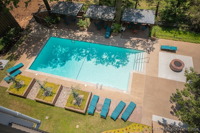 view of pool with a patio area and a fire pit