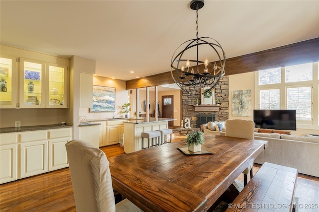 dining space featuring a chandelier, a fireplace, and light wood finished floors