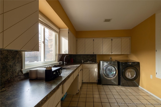 laundry room featuring light tile patterned floors, washing machine and dryer, laundry area, a sink, and visible vents