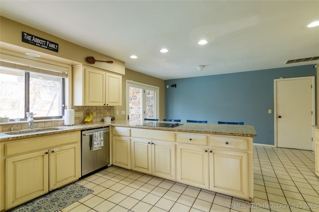 kitchen with visible vents, light countertops, stainless steel dishwasher, a sink, and a peninsula