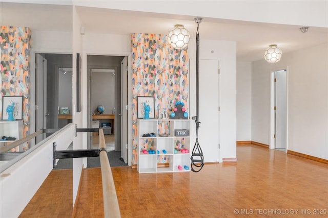 unfurnished dining area with wood finished floors and baseboards