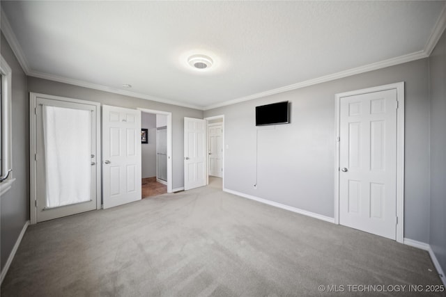 unfurnished bedroom featuring ornamental molding, carpet flooring, and baseboards