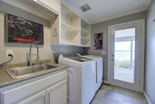 washroom with cabinet space, visible vents, ornamental molding, washing machine and clothes dryer, and a sink