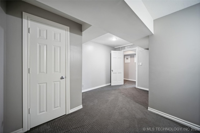 basement featuring baseboards, visible vents, and dark carpet