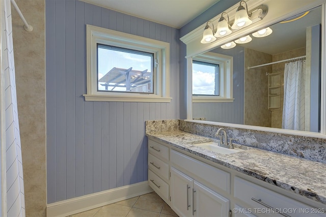 bathroom with baseboards, vanity, a shower with shower curtain, and tile patterned floors