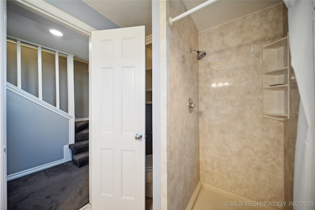 bathroom featuring a stall shower and toilet