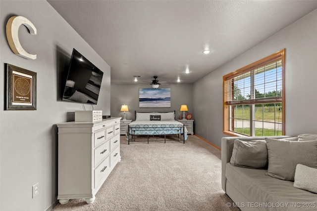 bedroom with light colored carpet, ceiling fan, a textured ceiling, and baseboards