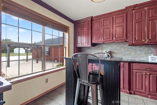 kitchen featuring reddish brown cabinets, a kitchen bar, and decorative backsplash