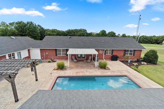 back of house with brick siding, a patio area, and an outdoor pool