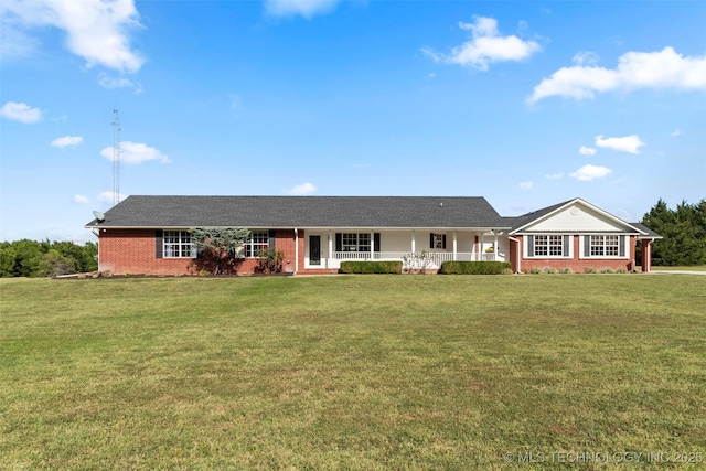 ranch-style home featuring a front yard, covered porch, and brick siding