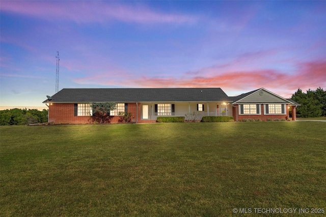 single story home with brick siding and a lawn