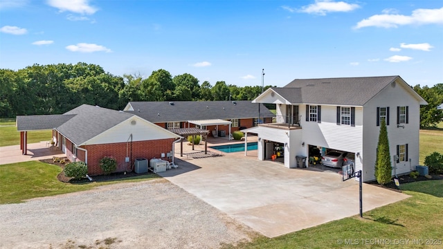 view of front of home featuring driveway, cooling unit, a front lawn, a carport, and brick siding