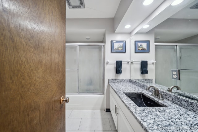 full bathroom with combined bath / shower with glass door, vanity, visible vents, and tile patterned floors