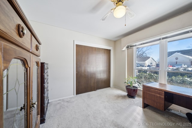 bedroom featuring a ceiling fan, a closet, and light colored carpet