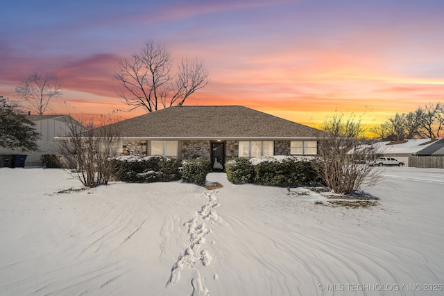 ranch-style house featuring stone siding