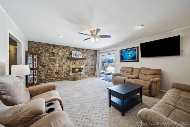 living area with ornamental molding, light carpet, a fireplace, and a ceiling fan