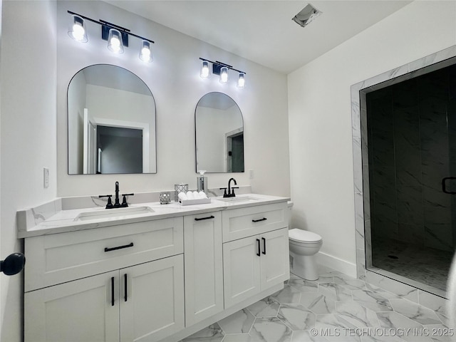 bathroom featuring double vanity, marble finish floor, a shower stall, and a sink