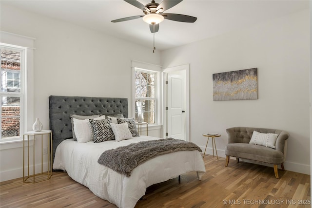 bedroom featuring ceiling fan, baseboards, and wood finished floors