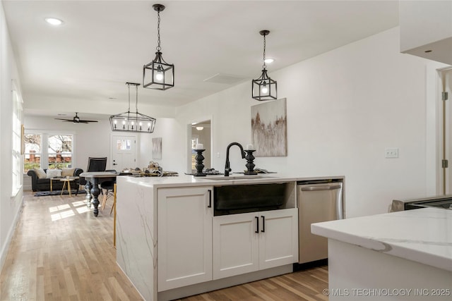 kitchen with dishwasher, open floor plan, decorative light fixtures, light stone countertops, and white cabinetry