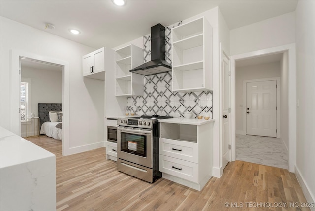 kitchen featuring open shelves, light countertops, electric range, white cabinetry, and wall chimney range hood