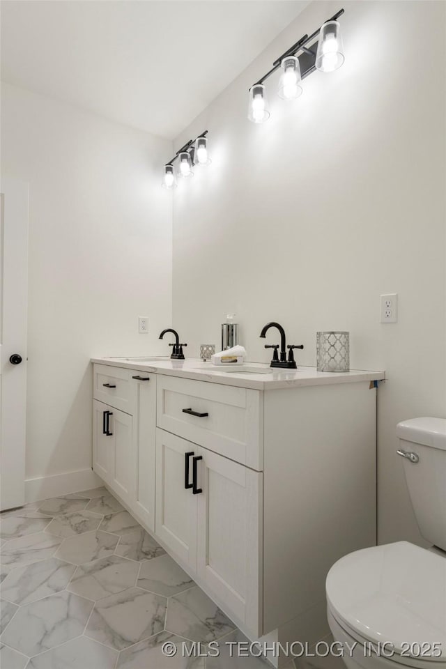 bathroom featuring marble finish floor, baseboards, vanity, and toilet