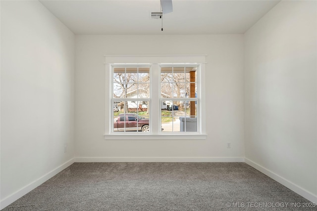 unfurnished room with carpet floors, baseboards, visible vents, and ceiling fan