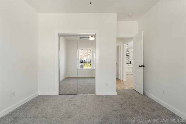 unfurnished bedroom with light carpet, baseboards, and a closet