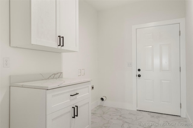 laundry area featuring marble finish floor, cabinet space, electric dryer hookup, and baseboards