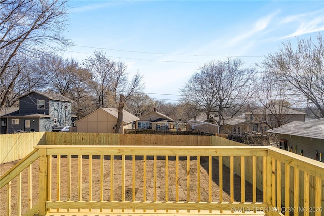 wooden terrace with a residential view and fence